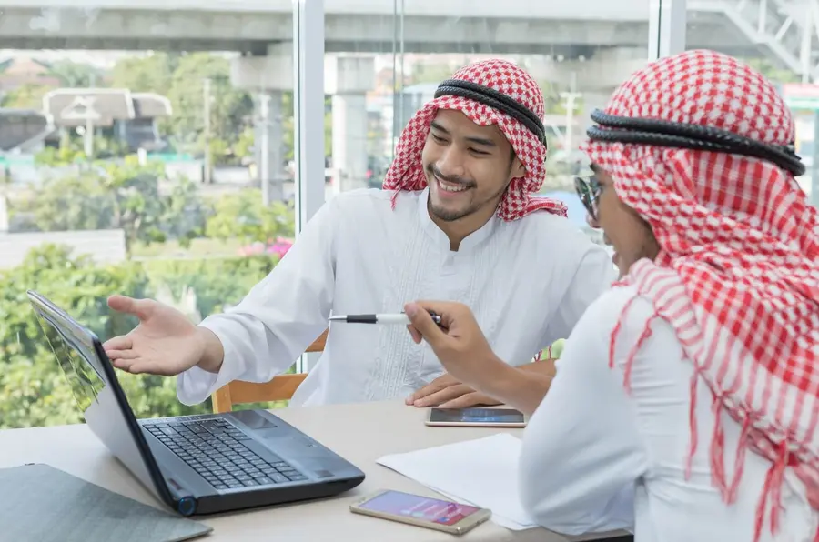 زميلان يراجعان مشروع تطبيق على حاسوب محمول